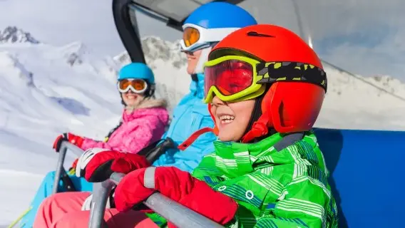 Family in a ski lift chair going up the slope